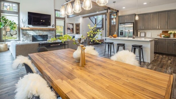A modern kitchen with a wooden dining table, bar stools, and pendant lighting. - Family Friendly w/ Suncadia Pool Access (Cle Elum)