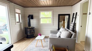 A cozy living room with a modern fireplace, a grey sofa, and a small white table.