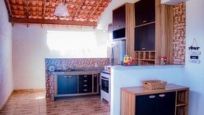 Una cocina con armarios de madera, horno integrado y salpicadero de azulejos.