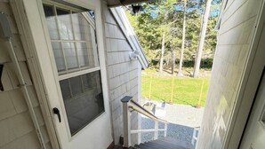 A wooden staircase leading to a door with a welcome mat.