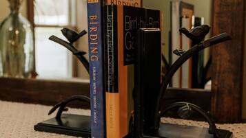 A stack of books on a wooden stand with a woven placemat underneath.