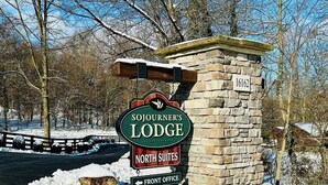 Un letrero de piedra para Sojourner's Lodge, con una señal que indica la dirección a la oficina principal.
