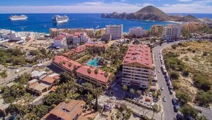 An aerial view of a coastal town with buildings, a road, and a beach. - CONDO MRS BY TRVL2HM (Cabo San Lucas)