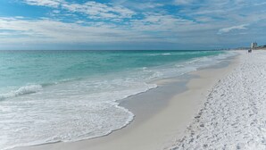 Een strand met helder turquoise water en een zandstrand.