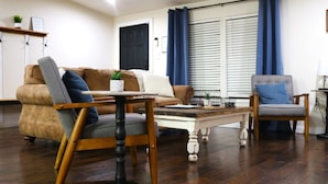 A living room with a brown sofa, a wooden coffee table, and a blue chair.