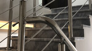 A staircase with metal railings and a black door at the top. - Abu Hossam’s chalet (Souf)