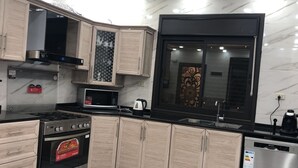 A modern kitchen with a built-in oven, microwave, and stainless steel dishwasher. - Abu Hossam’s chalet (Souf)