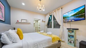 A neatly arranged bedroom with a bed, a television, a wardrobe, and a window with curtains. - ★Insta-Worthy Sunset View ★Private Rooftop ★Garage ★Silver Lake ★Dodgers Stadium (Los Angeles)