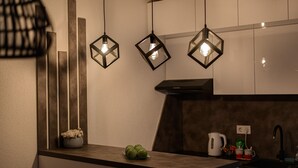 A modern kitchen with pendant lights, a countertop, and a sink.