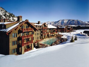 Experience the serene atmosphere of this traditional resort, surrounded by snow-covered mountains and a tranquil pool area.