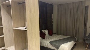 A modern bedroom with a bed, built-in shelving, and a small table. - Cosy, upscale apartment in California (Casablanca)