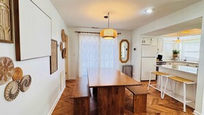 A modern kitchen with white cabinets, a built-in oven, and a coffee machine.