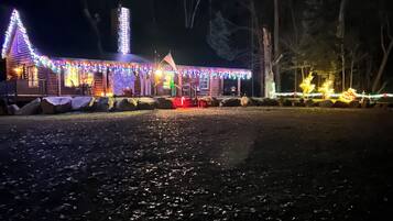 Une cabane en rondins décorée de guirlandes lumineuses colorées et dotée d’un porche.