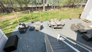 Un espace patio aménagé avec du mobilier d’extérieur, notamment une table et des chaises, ainsi qu’une terrasse en bois.