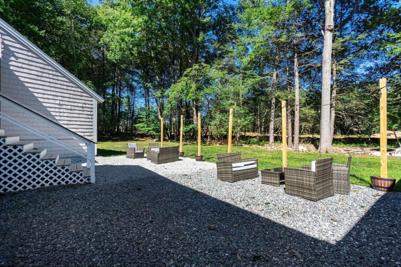 A patio area with outdoor furniture and a building with a sloped roof.
