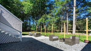 A patio area with outdoor furniture and a building with a sloped roof.