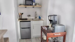 A compact kitchen with a microwave, coffee maker, toaster, and a small refrigerator. - Private basement w/firepit ideal for longer stays (Suwanee)