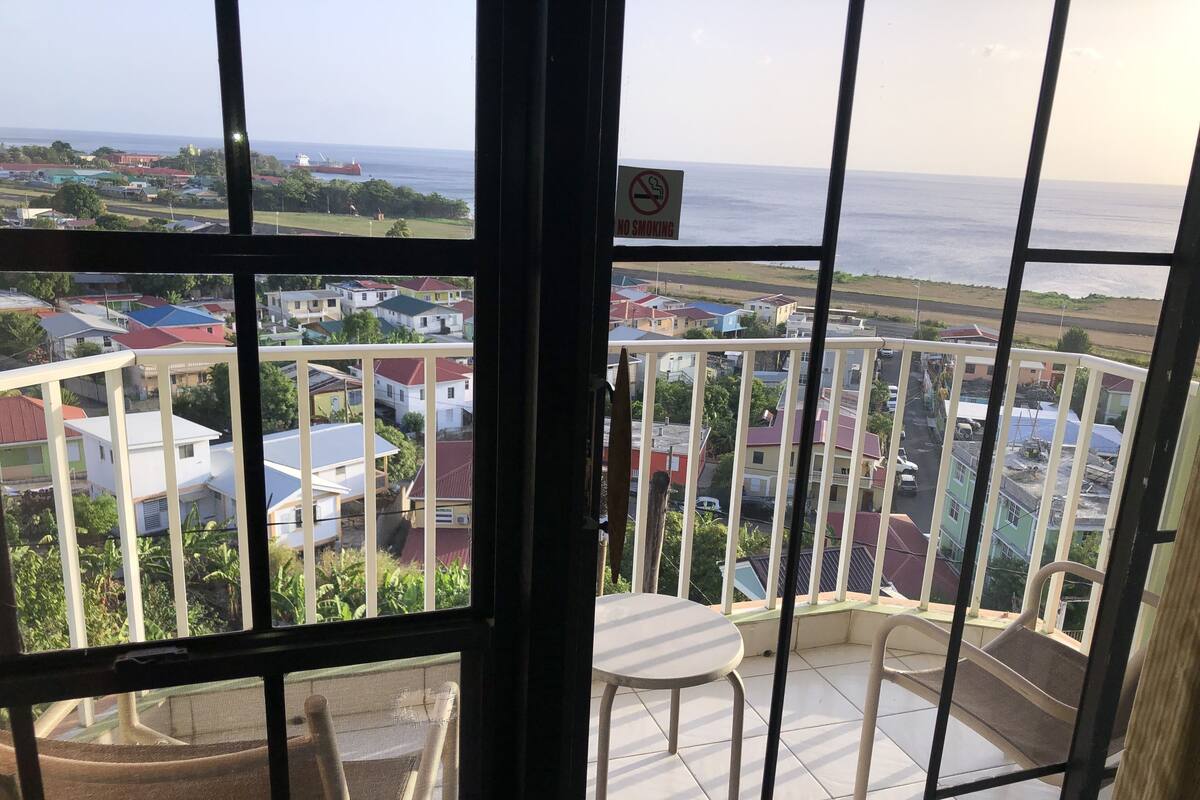 Un balcón con vista a una zona residencial y el mar.