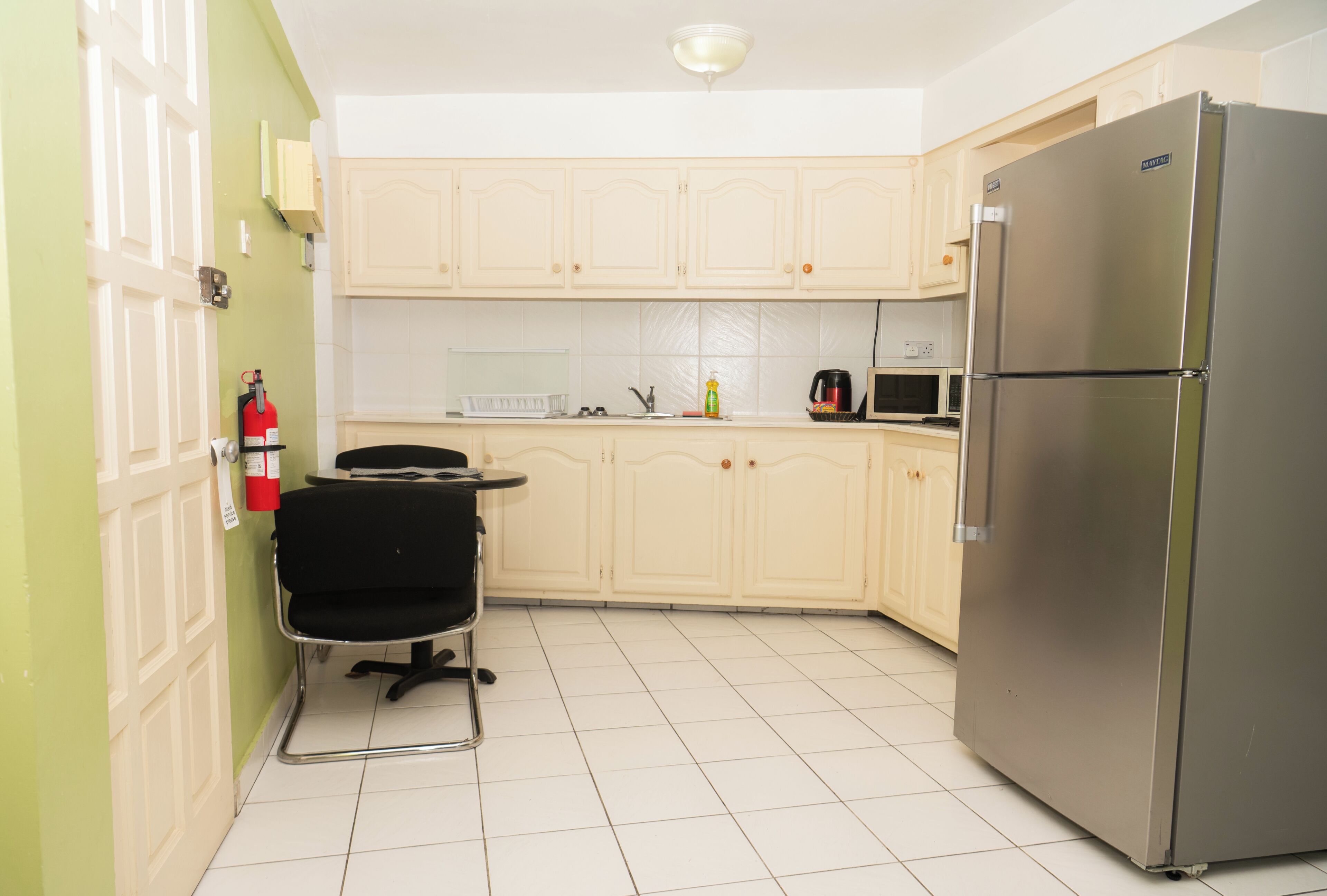 A kitchen with a refrigerator, a microwave, and a sink.