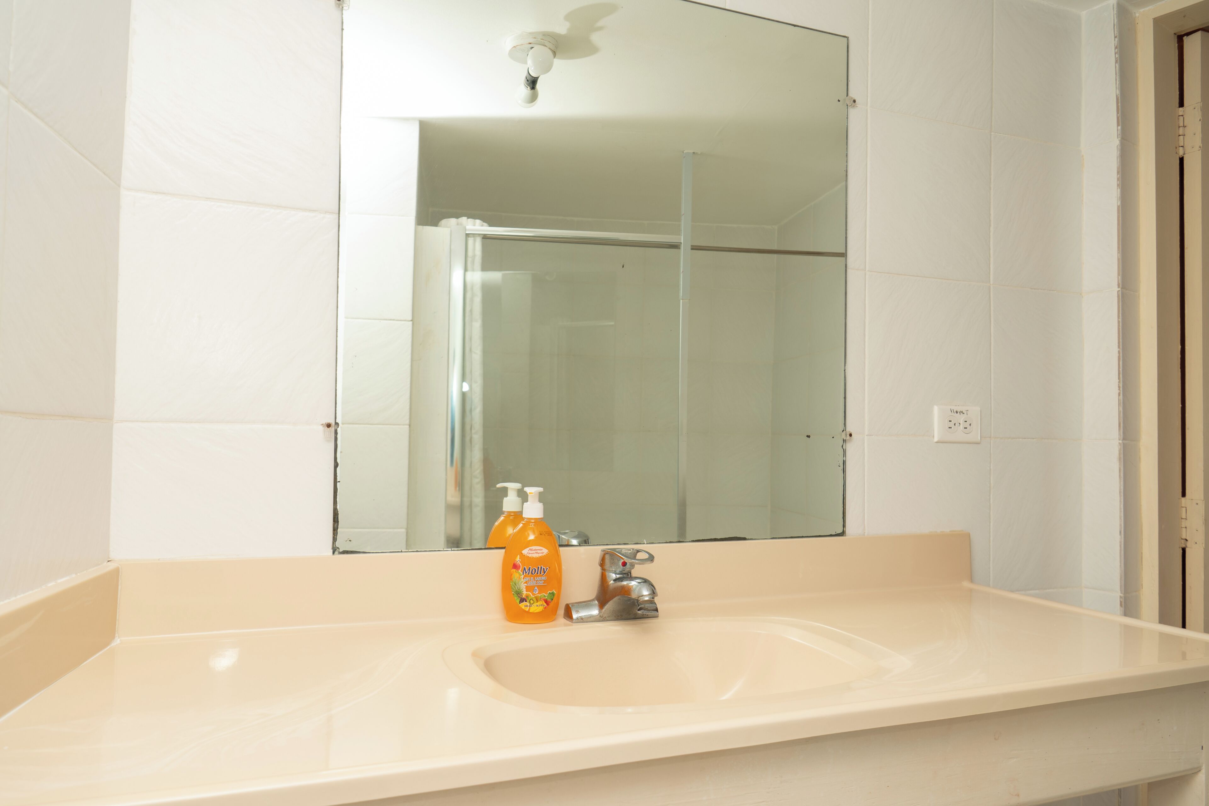 Une salle de bain avec un lavabo, un miroir et une douche.