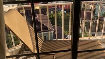 A balcony with a view of a residential area and the sea.