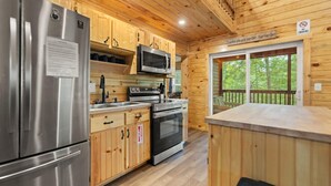 Una cocina moderna con electrodomésticos de acero inoxidable, armarios de madera y vistas al exterior.