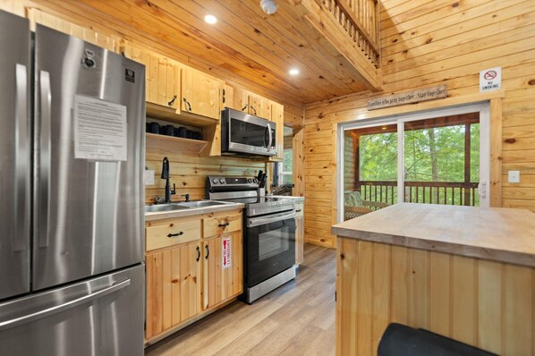 Una cocina moderna con electrodomésticos de acero inoxidable, armarios de madera y vistas al exterior.