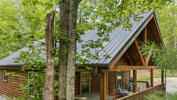 A log cabin with a wooden deck and a covered porch. - Secluded, forested, new cabin, 2-BR, 2-BA, Hot Tub, Wi-Fi, Smart TV's (Campton)