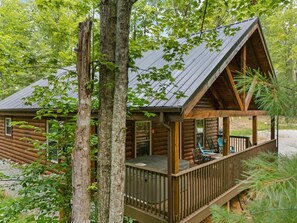 A log cabin with a wooden deck and a covered porch. - Secluded, forested, new cabin, 2-BR, 2-BA, Hot Tub, Wi-Fi, Smart TV's (Campton)