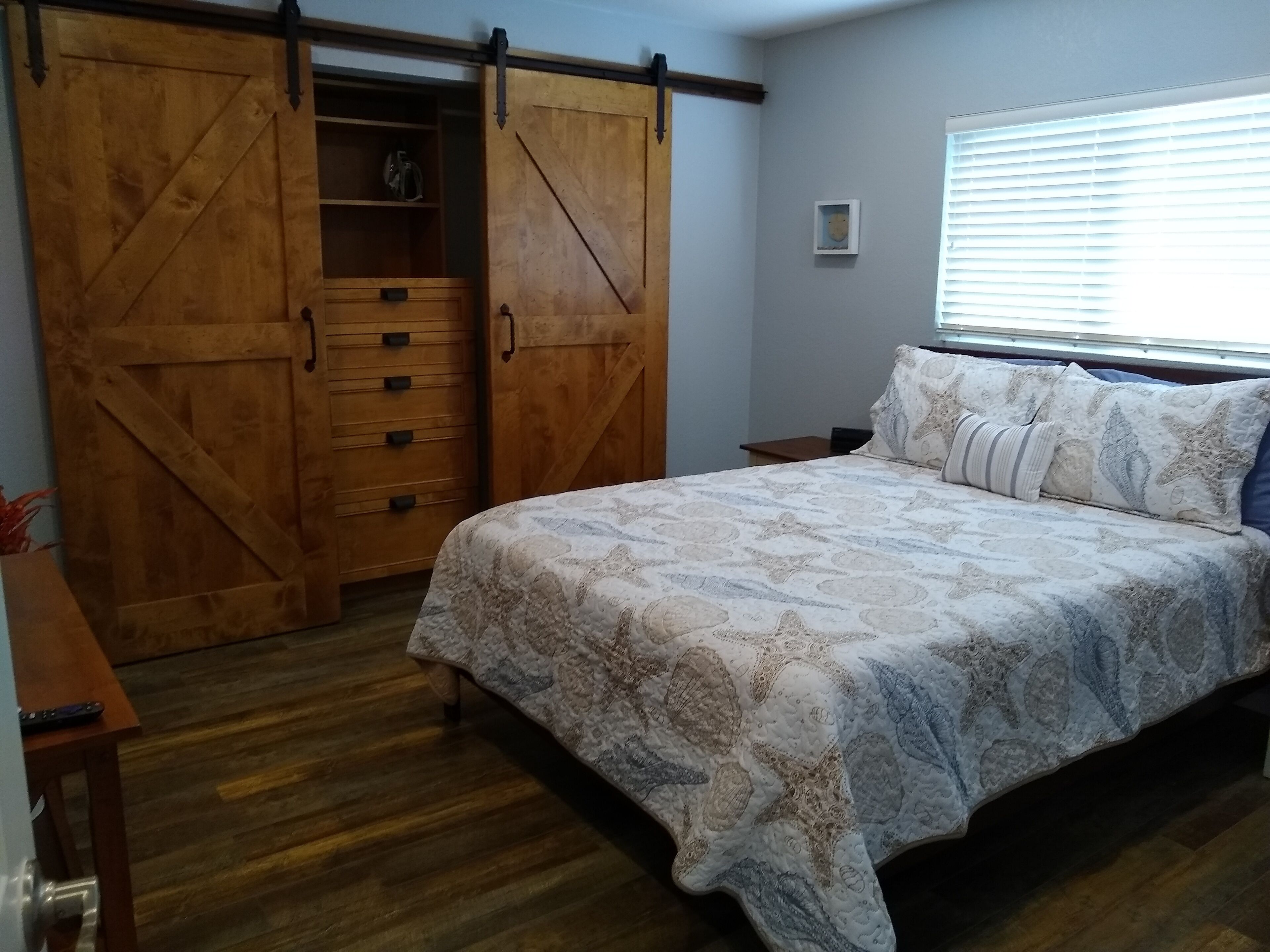 Une chambre à coucher avec un lit, une armoire en bois et une petite étagère.