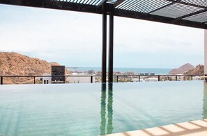 Una piscina infinita con vistas claras al océano y al paisaje urbano distante.