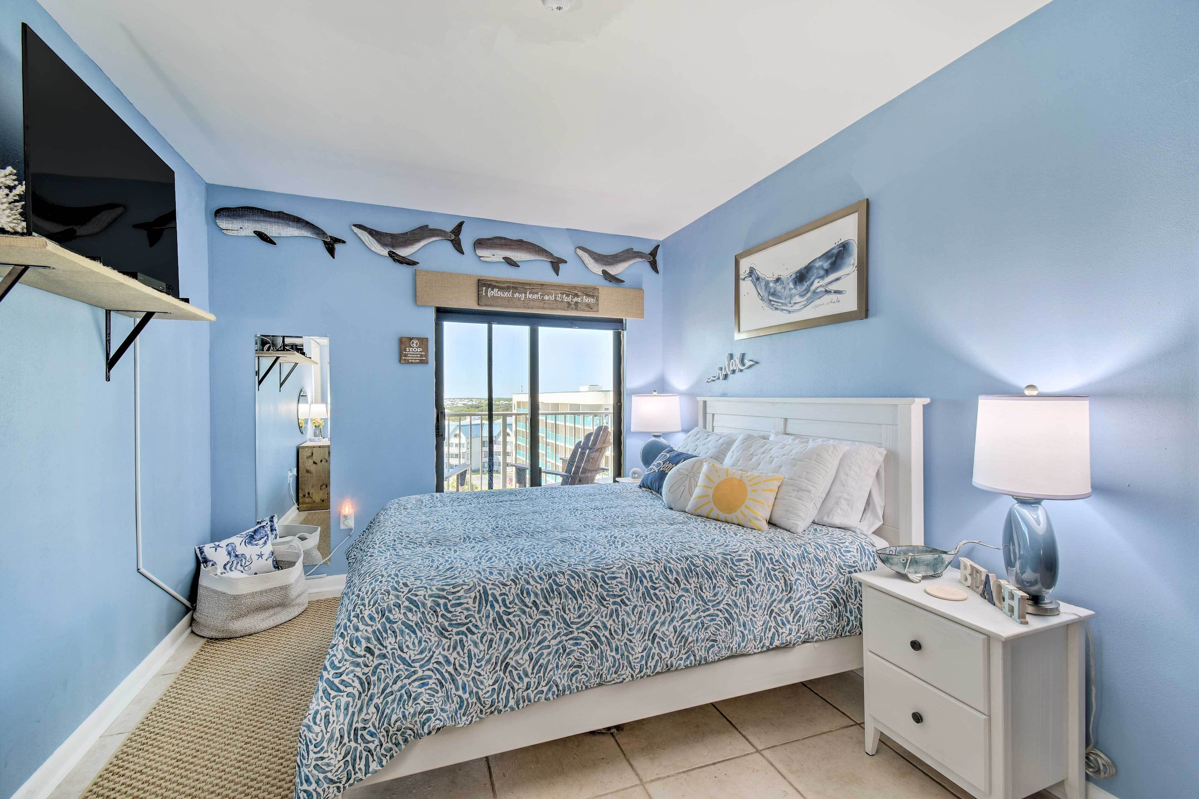 A bedroom with a bed, nightstand, and wall decorations including fish and a quote sign.