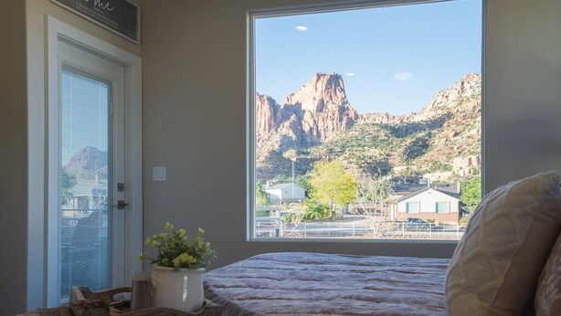Une chambre dotée d’une grande fenêtre donnant sur un paysage montagneux.