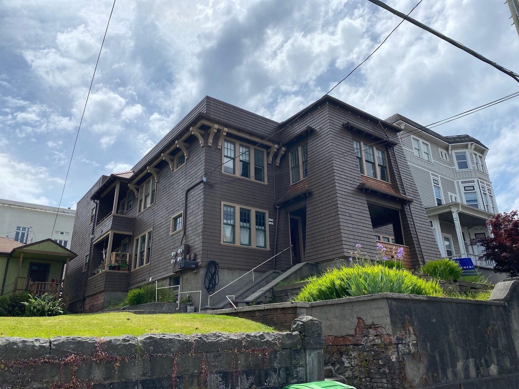A two-story house with a front porch, a garage, and a small garden area.