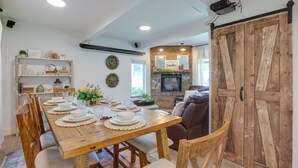 A dining area with a wooden table set for six, surrounded by chairs. A fireplace with a mirror above it is visible in the background. - Farmhouse w/ Private Hot Tub < 1 Mile to Birch Bay (Blaine)