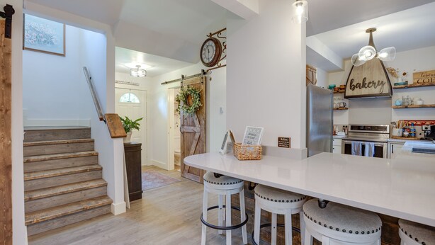 A kitchen with a large island, white stools, a clock, and a bakery sign. - Farmhouse w/ Private Hot Tub < 1 Mile to Birch Bay (Blaine)
