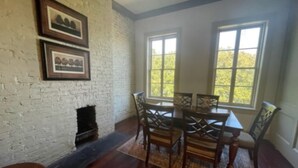 A dining area with a brick wall, wooden table, and chairs.