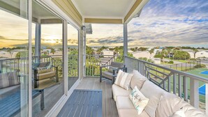 A balcony with a sofa, a chair, and a table.