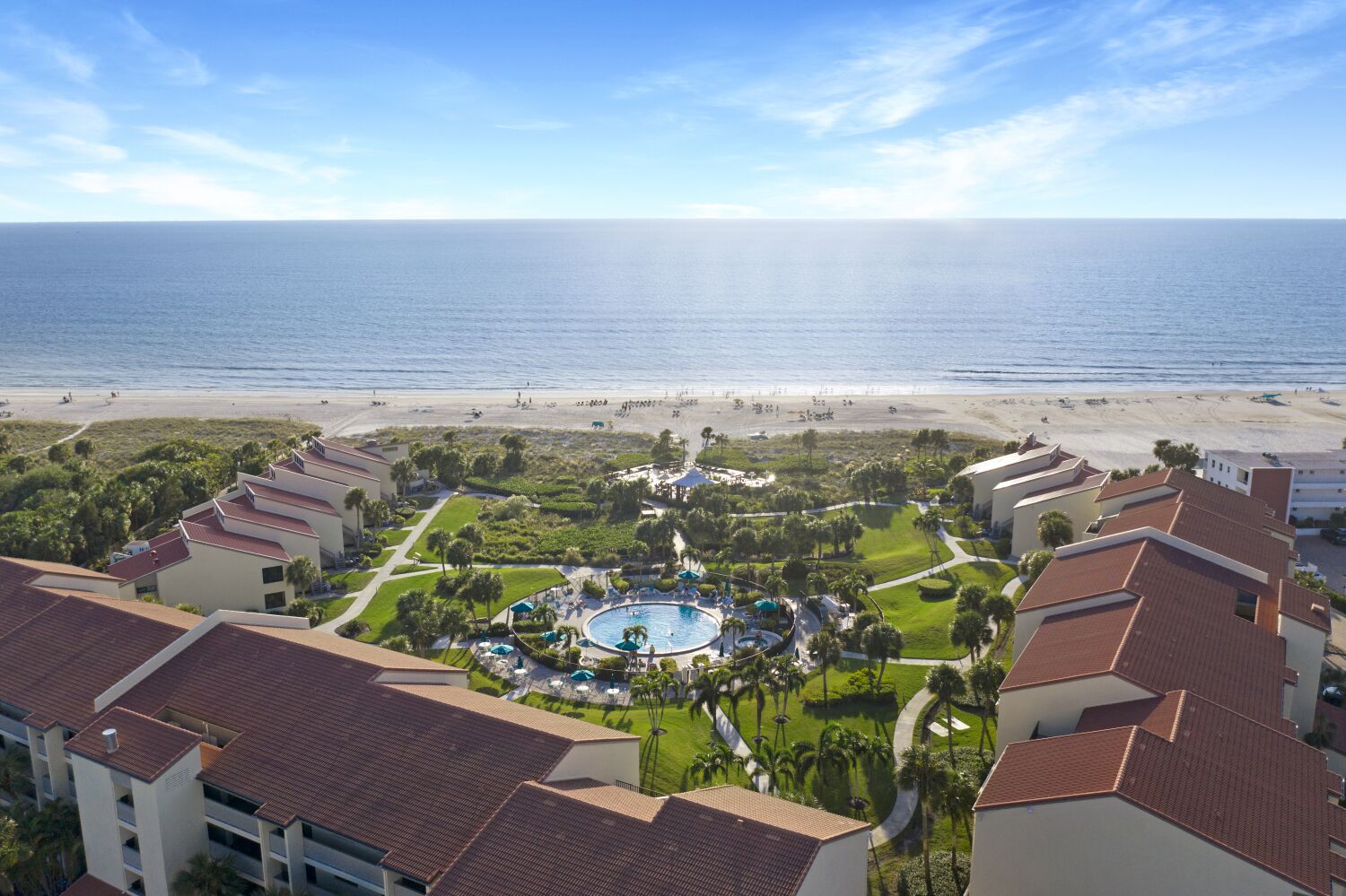 Resort com piscina, praia e vista para o oceano.