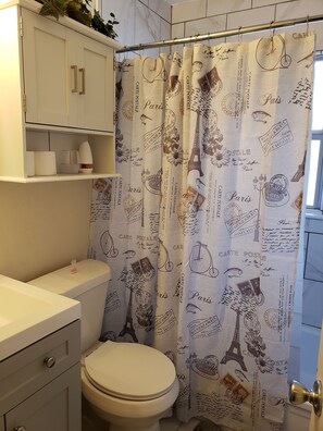 Een bad/douchecombinatie, een haardroger, handdoeken, zeep