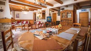 A cozy dining area with a wooden table set for a meal, surrounded by wooden chairs.