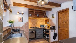 A compact kitchen with a sink, stove, microwave, and wooden cabinets.