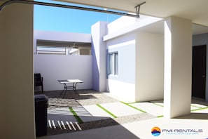 Ein moderner, offener Wohnbereich mit minimalistischem Design, inklusive Essbereich, Sitzgelegenheit und großem Fenster für viel Tageslicht.