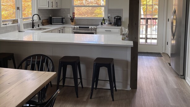 A spacious kitchen with a large island, modern appliances, and pendant lighting. - Secluded cabin in Hocking County (New Straitsville)