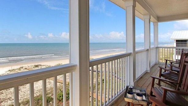 A covered porch with a view of the beach. - Luxurious 6-Bedroom Oceanfront Home with Private Pool in Gulf County. (Port St. Joe)