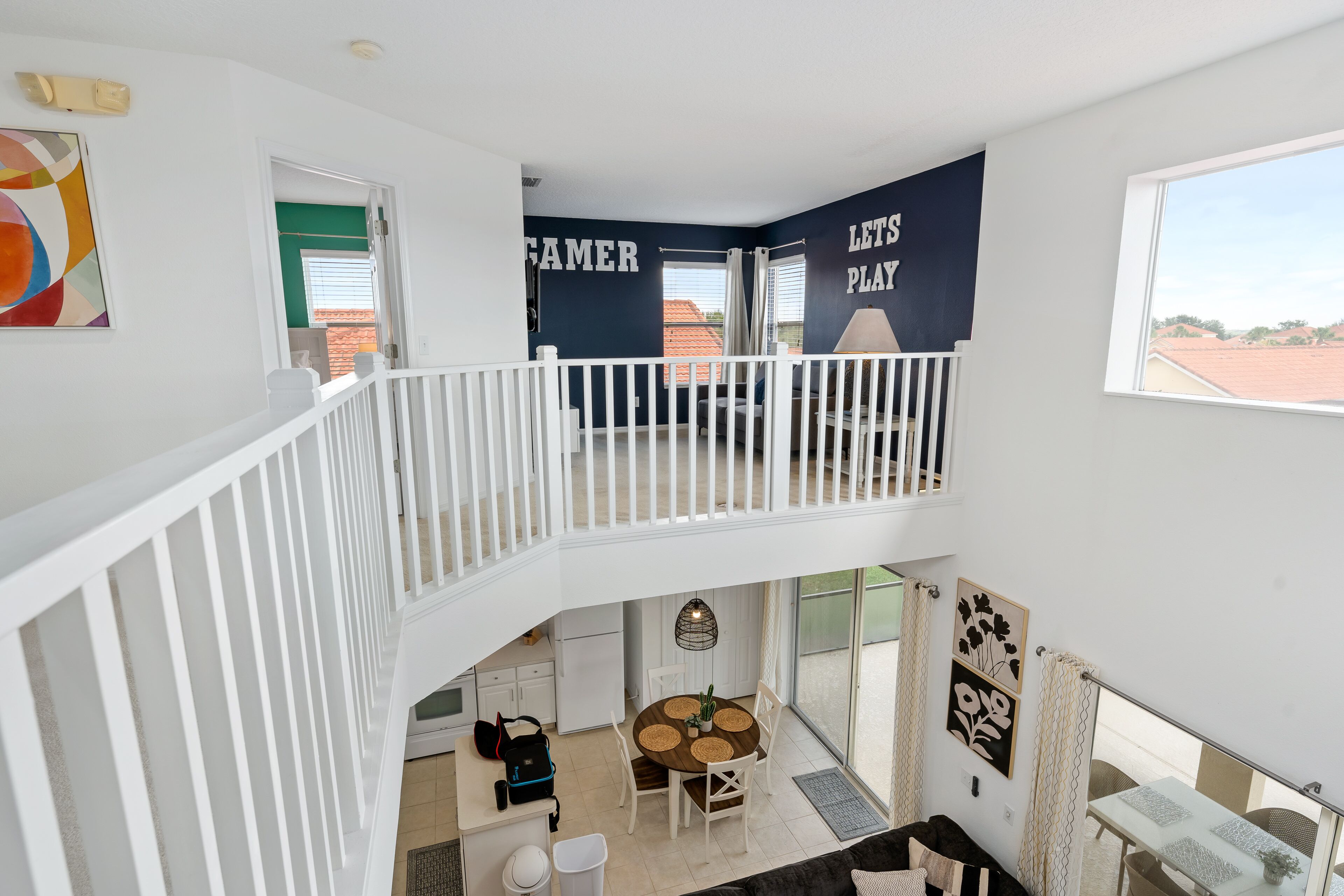 A multi-level interior with a balcony, a dining area, and a kitchen.