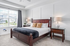 Ein ordentlich eingerichtetes Schlafzimmer mit einem hölzernen Bett, Nachttischen und einem Fenster mit Vorhängen.