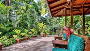 A wooden deck with potted plants and a bench.