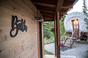 A wooden cabin with a sign reading "Bath." - North Haven Campground (Bonners Ferry)
