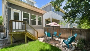 A backyard with a patio, outdoor furniture, and a wooden deck.